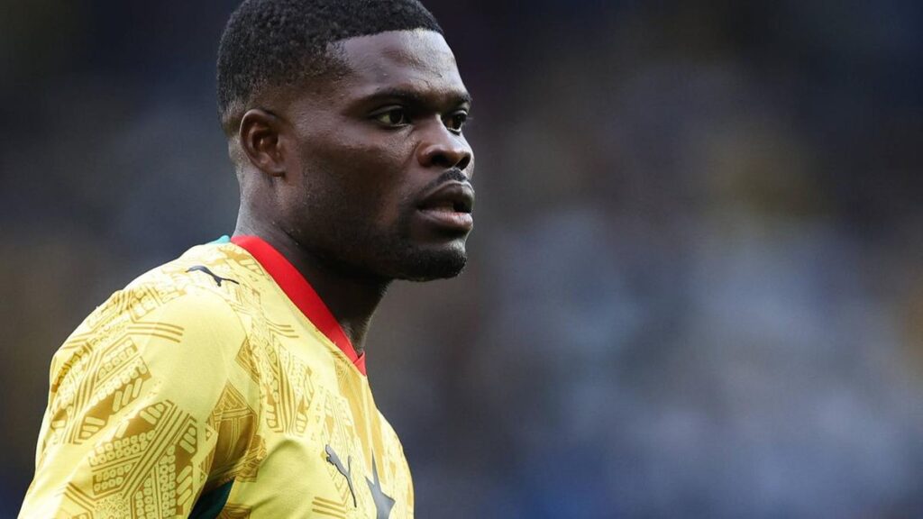 Thomas Partey im Trikot der ghanaischen Nationalmannschaft mit ernstem Gesichtsausdruck auf dem Spielfeld.