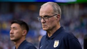 Marcelo Bielsa blickt angespannt vom Spielfeldrand, während uruguayische Spieler enttäuscht wirken