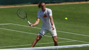 Alexander Zverev schlägt beim Tennis auf dem Rasenplatz fokussiert auf