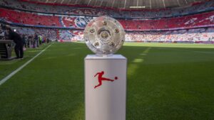 Das Logo der Bundesliga vor einem verschwommenen Fußballstadion