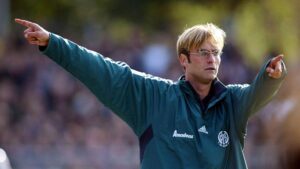 Jürgen Klopp lächelt im Trainingsanzug der deutschen Nationalmannschaft an der Seitenlinie