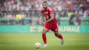 Jonathan Tah im Trikot des FC Bayern München blickt ernst und konzentriert auf dem Spielfeld.