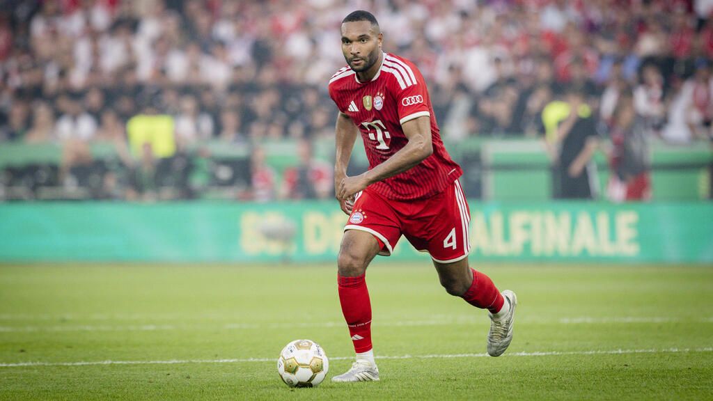 Jonathan Tah im Trikot des FC Bayern München blickt ernst und konzentriert auf dem Spielfeld.