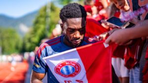 Alphonso Davies im Trikot des FC Bayern München schaut nachdenklich auf das Spielfeld