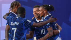 Kylian Mbappé und Trainer Didier Deschamps umarmen sich emotional nach einem Tor für Frankreich bei der Fußball-WM.