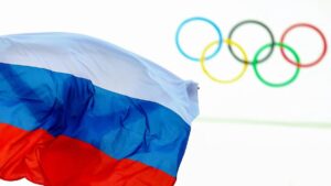 Die olympischen Ringe am Hauptquartier des IOC in Lausanne neben einer russischen Flagge