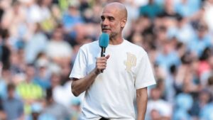Pep Guardiola gestikuliert im Anzug am Spielfeldrand