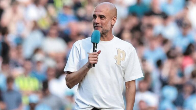 Pep Guardiola gestikuliert im Anzug am Spielfeldrand