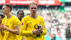 Julian Brandt im Trikot von Borussia Dortmund schaut nachdenklich auf das Spielfeld.