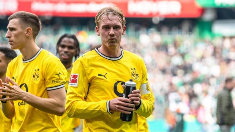 Julian Brandt im Trikot von Borussia Dortmund schaut nachdenklich auf das Spielfeld.