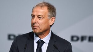 Jürgen Klinsmann gestikuliert mit ernstem Blick während eines Interviews am Spielfeldrand