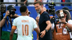Jürgen Klopp schaut nachdenklich, im Hintergrund ist verschwommen das DFB-Logo zu erkennen