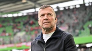 Jonas Urbig im Trikot der Nationalmannschaft blickt konzentriert über das Spielfeld.