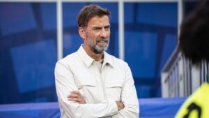 BVB-Legende Jürgen Kohler blickt ernst, im Hintergrund Jürgen Klopp als designierter DFB-Trainer
