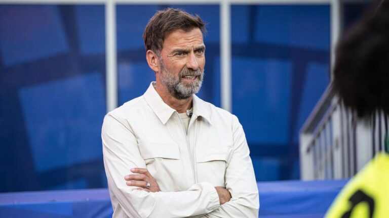BVB-Legende Jürgen Kohler blickt ernst, im Hintergrund Jürgen Klopp als designierter DFB-Trainer
