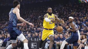 LeBron James blickt fokussiert auf das Basketballfeld, im Hintergrund das Logo der Philadelphia 76ers