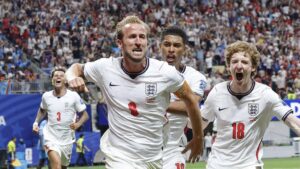 Erling Haaland und Harry Kane blicken fokussiert auf das Spielfeld vor dem WM-Viertelfinale Norwegen gegen England