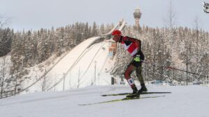 Ein enttäuschter Athlet der Nordischen Kombination im Schnee nach einem Wettkampf