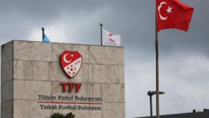 Polizeiautos mit Blaulicht vor einem türkischen Fußballstadion während einer Razzia