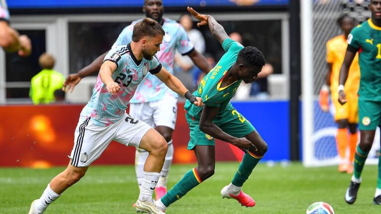 Bara Sapoko Ndiaye lächelt bei der Vertragsunterschrift im Trikot des FC Bayern München