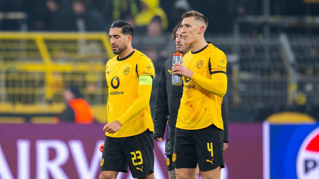 Emre Can und Nico Schlotterbeck im Trikot von Borussia Dortmund blicken ernst auf das Spielfeld