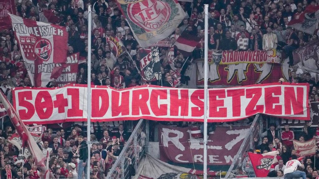 Fans in einem deutschen Bundesligastadion mit Bannern zur 50+1-Regel