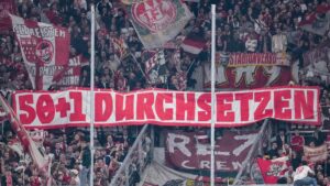 Fans in einem deutschen Bundesligastadion mit Bannern zur 50+1-Regel