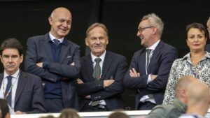 DFB-Aufsichtsrat Alexander Wehrle blickt ernst, im Hintergrund ist das Logo der FIFA zu sehen.