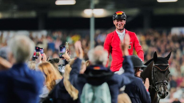 Das deutsche Springreiter-Team jubelt über die Goldmedaille bei der Weltmeisterschaft in Aachen unter Flutlicht.