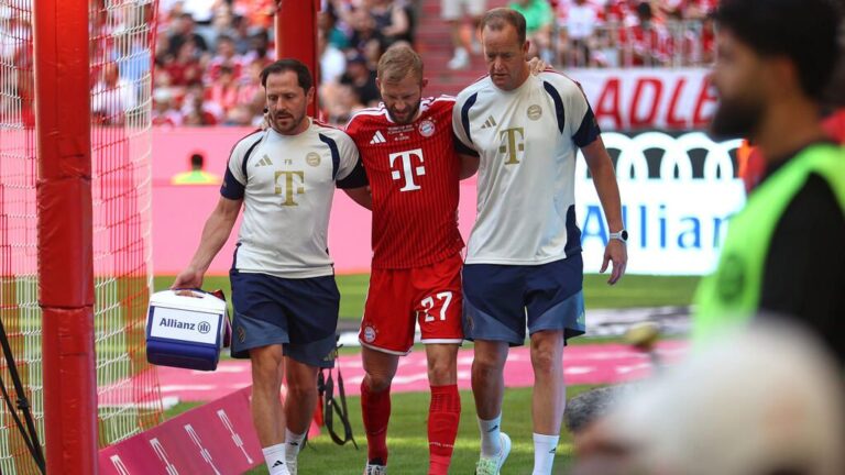 Konrad Laimer vom FC Bayern München wird nach seiner Verletzung von Betreuern vom Platz geführt.