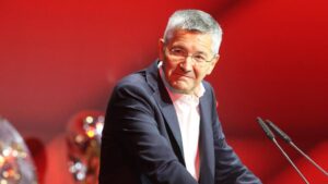 Präsident Herbert Hainer vor dem Logo des FC Bayern München