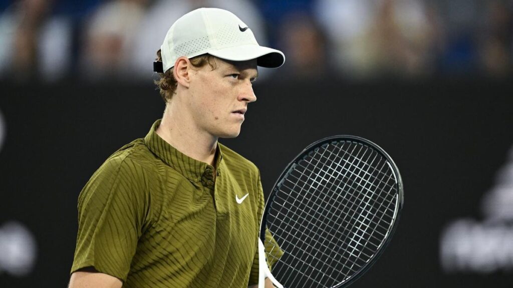 Jannik Sinner blickt enttäuscht auf dem Tennisplatz, nachdem ihn Knieprobleme zur Absage zwingen.
