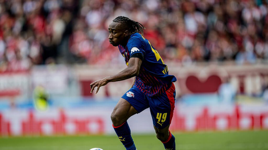 Yan Diomande im Trikot von RB Leipzig schaut fokussiert auf das Spielfeld.