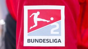 Fußball auf dem Rasen beim Anstoß der 2. Bundesliga in einem gut besuchten Stadion unter Flutlicht
