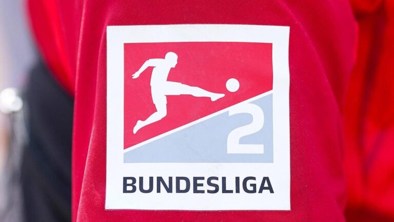 Fußball auf dem Rasen beim Anstoß der 2. Bundesliga in einem gut besuchten Stadion unter Flutlicht