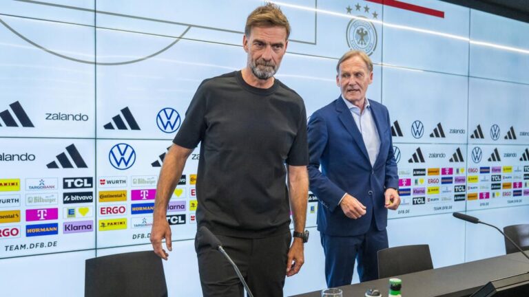 Uli Hoeneß schaut skeptisch auf der Tribüne, während Jürgen Klopp am Spielfeldrand steht.