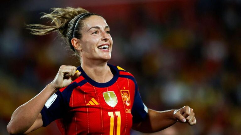 Alexia Putellas steht lächelnd auf der Bühne und hält die Trophäe des Ballon d'Or in den Händen.