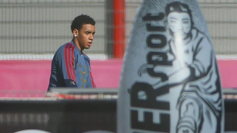 Jamal Musiala im Trikot des FC Bayern München blickt enttäuscht auf das Spielfeld.