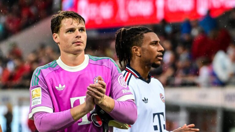 Torhüter Jonas Urbig vom FC Bayern München im Trainingsanzug auf dem Rasen.