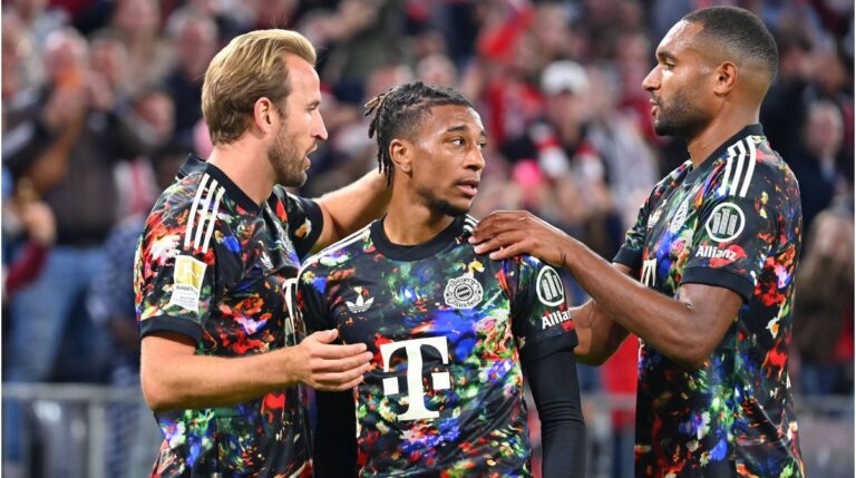 Jan-Christian Dreesen im Anzug vor dem Vereinslogo des FC Bayern München