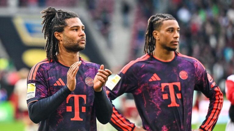 Serge Gnabry im Trikot des FC Bayern München blickt fokussiert auf das Spielfeld.