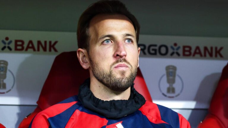Harry Kane sitzt im Trainingsanzug auf der Auswechselbank des FC Bayern München