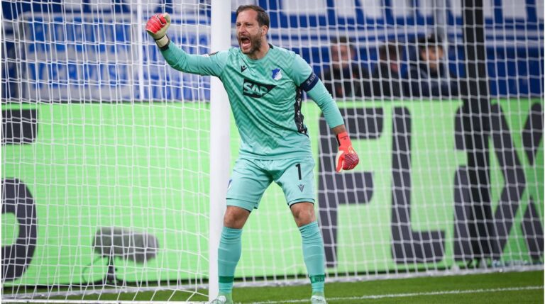 Oliver Baumann gestikuliert enttäuscht im Trikot der TSG Hoffenheim auf dem Spielfeld.