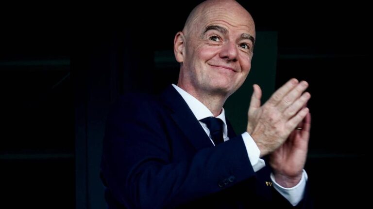 FIFA-Präsident Gianni Infantino steht vor einem Rednerpult im Anzug
